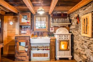 a kitchen with a stone wall and a stove at Baita delle Bambole - La Vista Apartments in Isola +11 photos