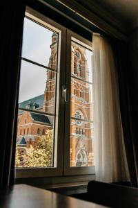 une fenêtre avec vue sur une église dans l'établissement B&B Vrijheid 4, à Arendonk