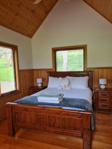 una camera da letto con un letto grande con due finestre di Maple Ridge Cottages a Dumbalk Altre 167 foto