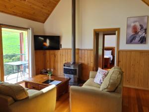 un soggiorno con 2 divani e un piano cottura di Maple Ridge Cottages a Dumbalk
