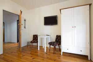 a room with a table and two chairs and a tv at Apartament na Fatimskiej in Krakow