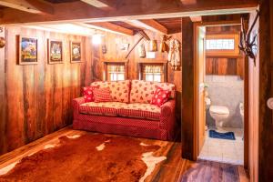 - un salon avec un canapé rouge dans la salle de bains dans l'établissement Baita delle Bambole - 400 metri dal LAGO, à Isola