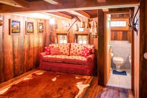 a living room with a red couch in a bathroom at Baita delle Bambole - La Vista Apartments in Isola