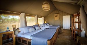 - une chambre avec 2 lits dans une tente dans l'établissement Zawadi Camp, à Serengeti