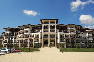 a large building with cars parked in front of it at ARENA Apart Complex in Sveti Vlas