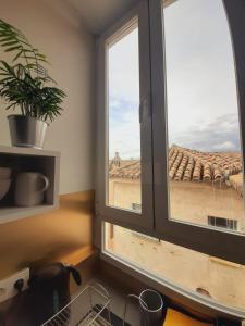 een keukenraam met uitzicht op een dak bij Golden Realejo Guest house in Granada