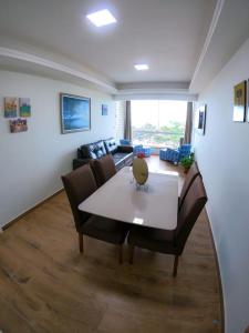 sala de estar con mesa y sofá en Apartamento de frente para o mar, en Guarapari