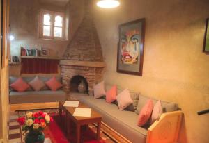 ein Wohnzimmer mit einem Sofa und einem Kamin in der Unterkunft Riad Dar Afram in Essaouira