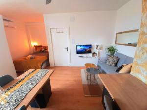 een woonkamer met een blauwe bank en een tafel bij Golden Realejo Guest house in Granada