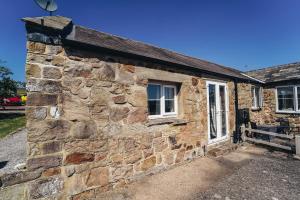 a stone house with a window and a stone wall at Cottages in Derbyshire - Orchard Cottage in Belper