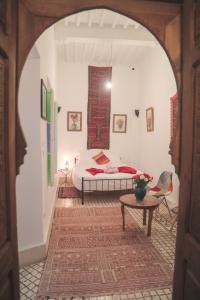 Schlafzimmer mit einem Bett und einem Tisch in der Unterkunft Riad Dar Afram in Essaouira