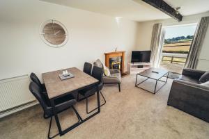 a living room with a table and chairs and a couch at Cottages in Derbyshire - Orchard Cottage in Belper