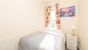 a white bedroom with a bed and a window at Luxury Shirley Apartments close to Solent Uni and Southampton Central Train Station in Southampton