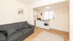 a living room with a gray couch and a kitchen at Luxury Shirley Apartments close to Solent Uni and Southampton Central Train Station in Southampton
