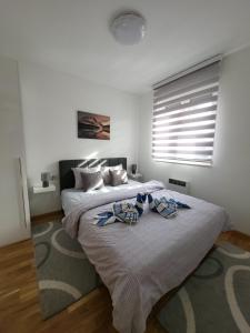 Vila Marija Zlatibor - Apartman 2 في زلاتيبور: غرفة نوم مع سرير كبير مع ربطتين قوسين عليه