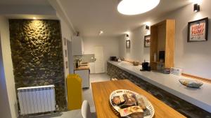 a kitchen with a table and a stone wall at V13 Wild Cabin - Traditional mountain cabin with cosy modern rooms in Gura Teghii