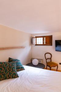 a bedroom with a white bed and a chair at Villa Il Mosaico in Florence