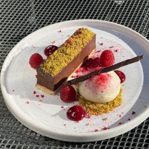a piece of chocolate cake and raspberries on a plate at Sibton White Horse Inn in Saxmundham