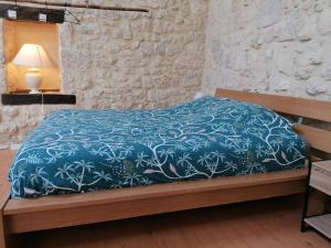 a bedroom with a bed with a blue comforter at LE LOFT in Casteljaloux