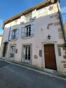 a large white building with windows and a door at La chapellerie in Caunes-Minervois