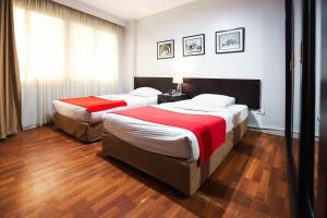 two beds in a hotel room with wood floors at NewCity Hotel & Suites in Cairo