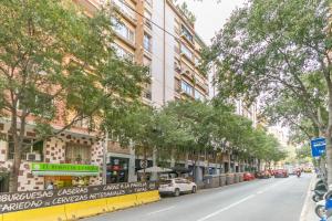 Elegance Barcelona Rentals في برشلونة: شارع فيه اشجار وسيارات تقف في الشارع