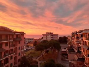 una puesta de sol sobre una ciudad con edificios y árboles en Andora Fronte Mare, en Andora 1 foto más