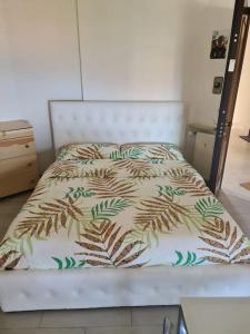 1 cama en un dormitorio con colcha de hojas en Andora Fronte Mare, en Andora