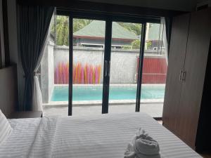 a bedroom with a bed with a view of a pool at Aonang Oscar Pool Villas in Ao Nang Beach
