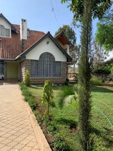 uma casa com uma palmeira em frente em Teresita Home em Nairobi