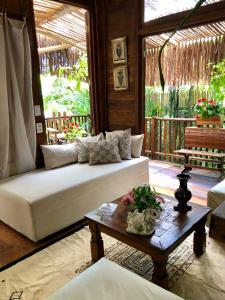 a living room with a white couch and a table at Bangalô Maria Eliza, luxo próximo ao mar in Trancoso