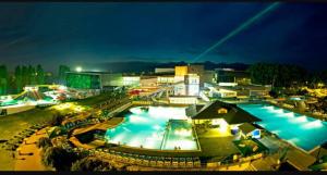 a large swimming pool at a resort at night at MBV28 Apartments in Poprad