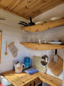 cocina con estanterías de madera y mesa de madera en The Shepherds Hut at Forestview Farm en Greenisland