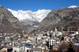 a city with snow covered mountains in the background at Grand Hotel Royal E Golf in Courmayeur