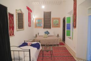 Riad Dar Afram في الصويرة: غرفة فيها سرير وطاولة فيها