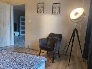 a room with a lamp and a chair in a room at Senza apartman in Bratislava