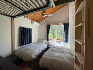 sypialnia z łóżkiem i oknem w obiekcie スイートヴィラ 四季terrace箱根仙石原 w mieście Sengokuhara