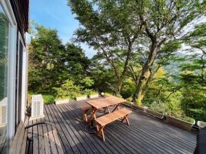 drewniany taras ze stołem i ławką w obiekcie スイートヴィラ 四季terrace箱根仙石原 w mieście Sengokuhara