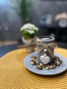a candle on a plate with nuts and a heart on it at Apartman Stefan Lux in Vrdnik
