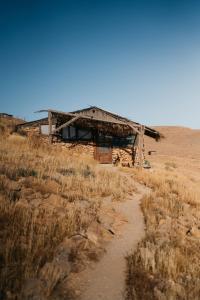 un viejo edificio en medio de un campo en Succah in the Desert en Mitzpe Ramon