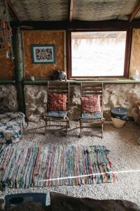 a living room with two chairs and a rug at Succah in the Desert in Mitzpe Ramon
