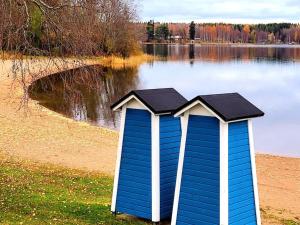 uma cabana azul e branca sentada em frente a um lago em Modern apartment with free parking & Netflix. em Ylöjärvi