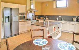 eine Küche mit Tisch und Kühlschrank in der Unterkunft Lovely Home In Valojoulx in Valojoulx