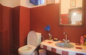 een badkamer met een toilet, een wastafel en een spiegel bij Riad Dar Afram in Essaouira