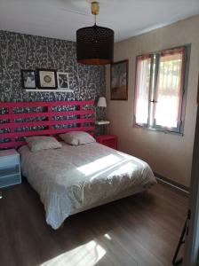 a bedroom with a large bed with a pink headboard at Chambre privée dans chalet au calme in Saint-Brisson