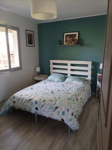 a bedroom with a bed and a green wall at Chambre privée dans chalet au calme in Saint-Brisson