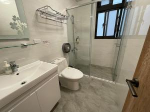 a bathroom with a toilet and a shower and a sink at Lily's House in Zhushan