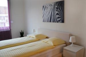 1 dormitorio con 1 cama y una pintura en la pared en Rent a Home Landskronstrasse - Self Check-In en Basilea