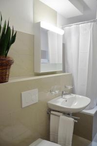 ein Badezimmer mit einem Waschbecken, einem WC und einem Spiegel in der Unterkunft Rent a Home Landskronstrasse - Self Check-In in Basel