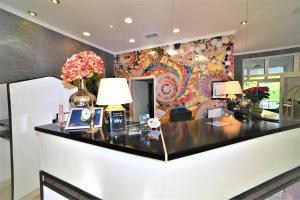 a lobby with a counter with flowers on it at Ascot Hotel in Remscheid